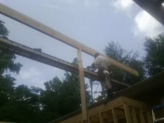 Carpenter setting a ridge beam over a new addition frame — Ice Dam Removal by Roofing Brothers in Wishram